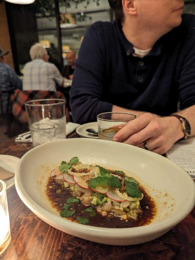 a person sitting at a table with a plate of food