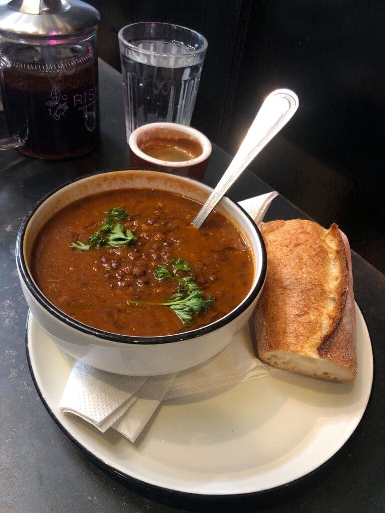 a bowl of soup and a sandwich on a plate