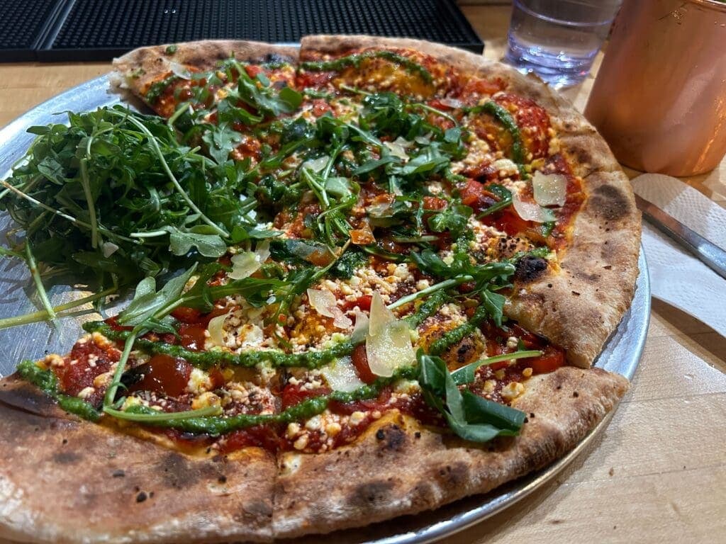 a pizza sitting on top of a wooden table