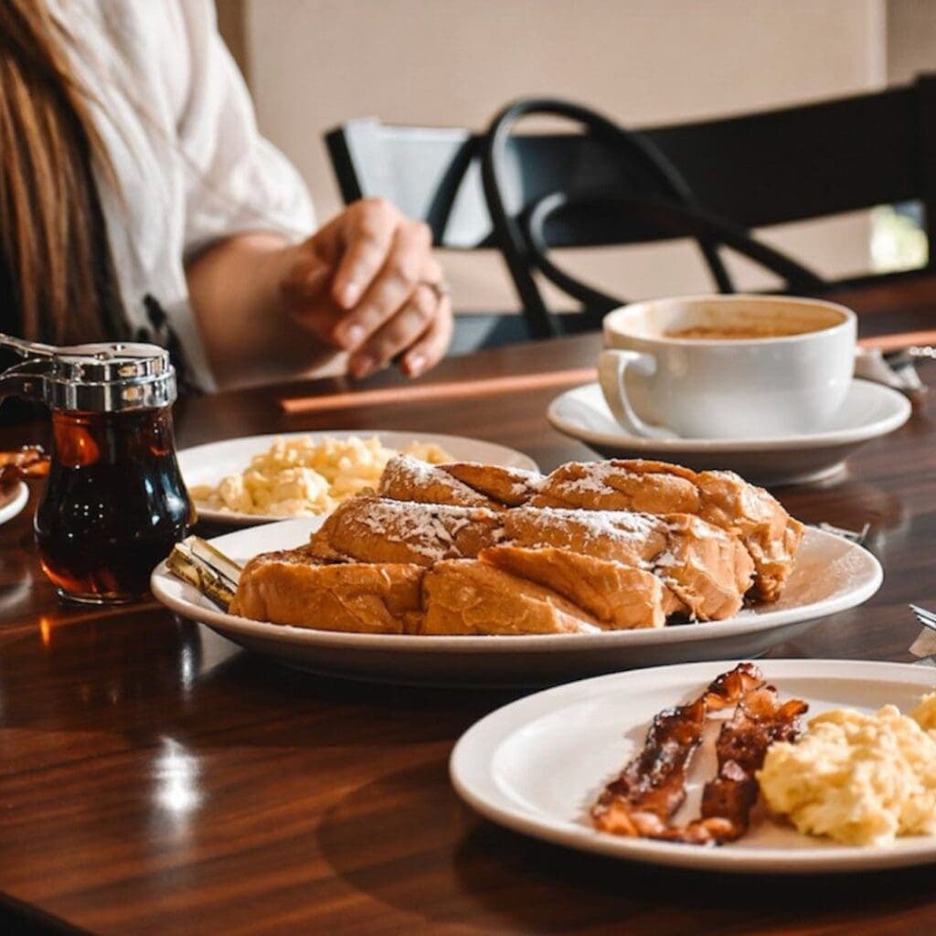a person sitting at a table with a plate of food