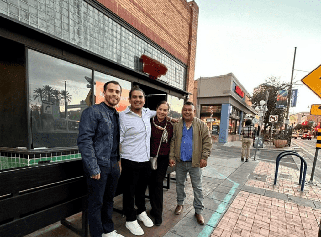 a group of people standing on a sidewalk