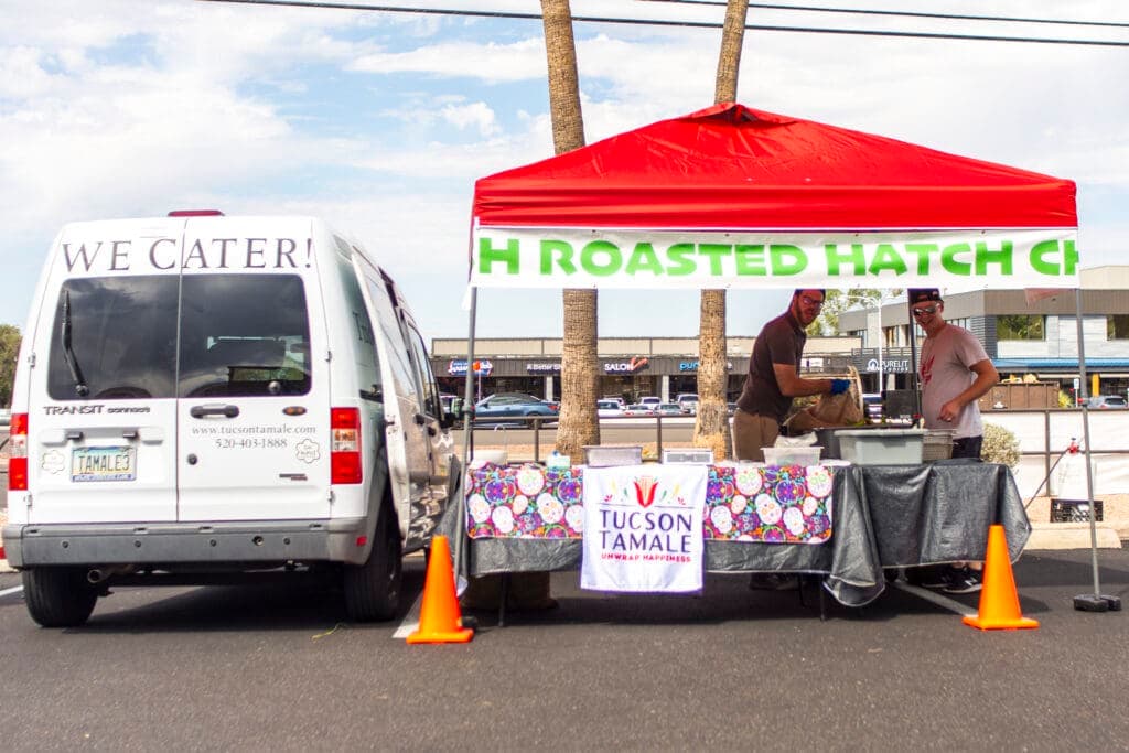 a group of people standing outside of a food truck
