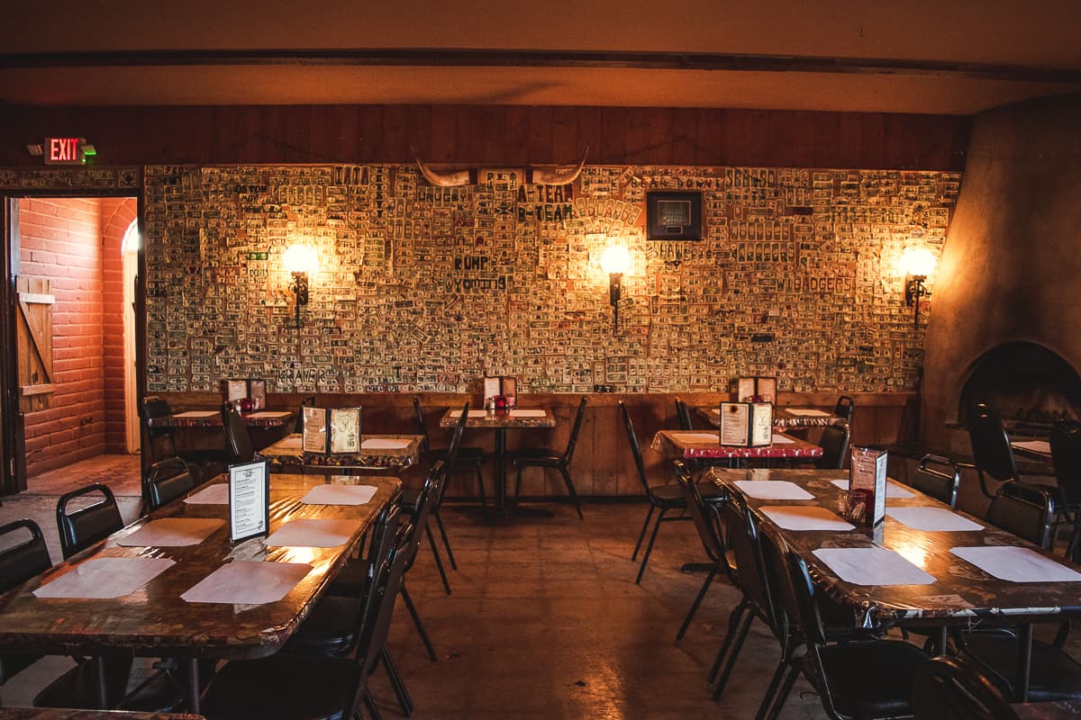 Dollar bill-decorated wall in the dining room at Daisy Mae's Steak House (Credit: Jackie Tran)