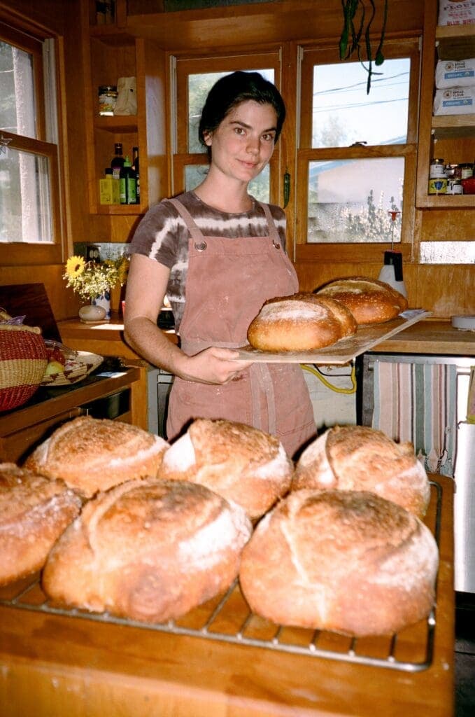 a woman standing by a table with food