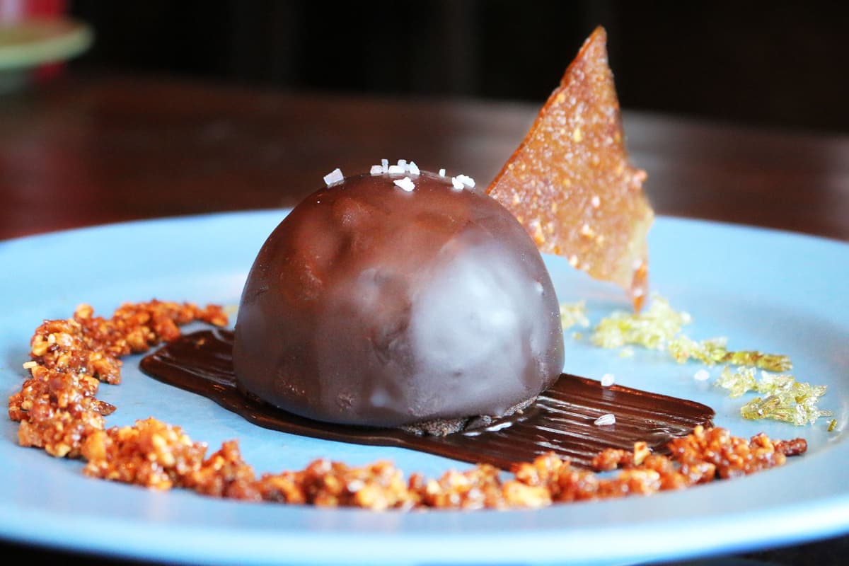 Chocolate Cajeta Bombe - Flourless Chocolate Cake, Vanilla Bean Mousse, Chocolate Sauce, and Oaxacan Peanut Brittle