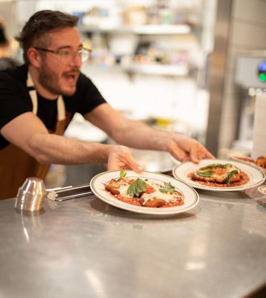 a person sitting at a table with a plate of pizza
