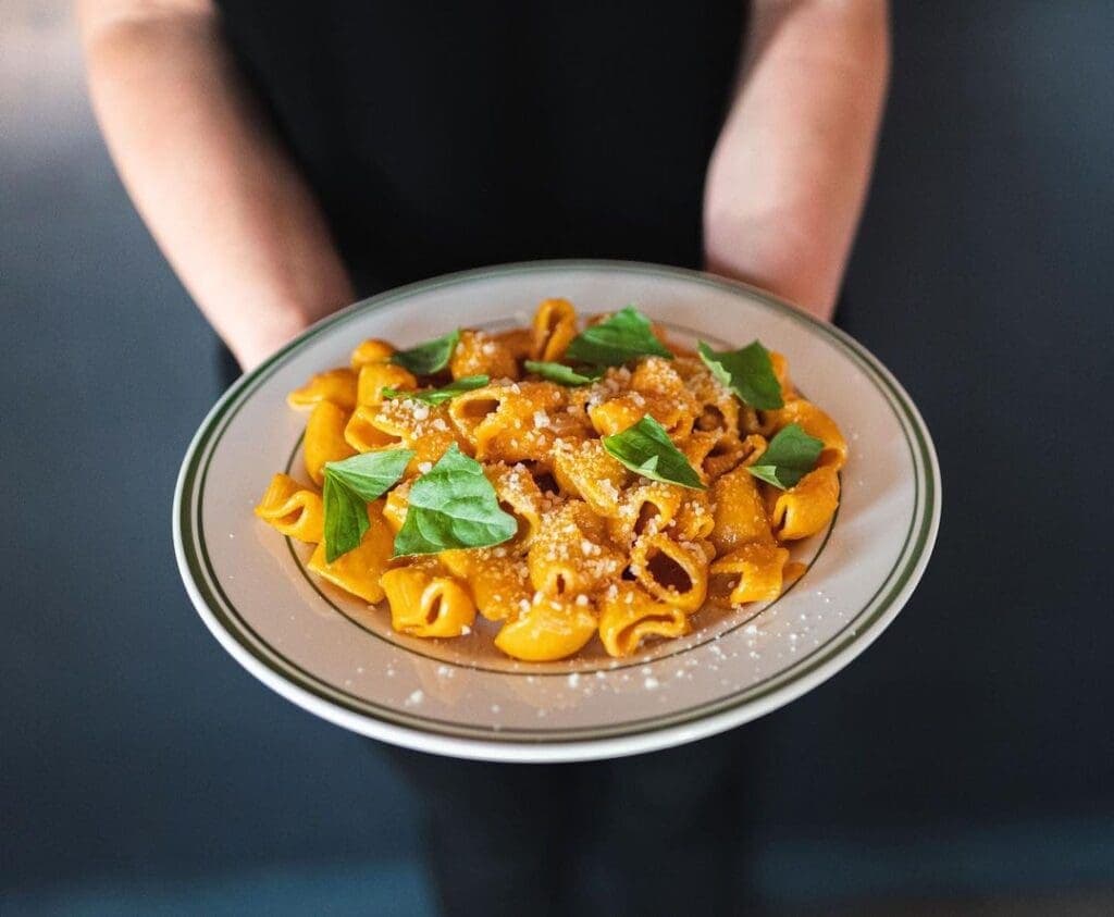 a person holding a bowl of food on a plate