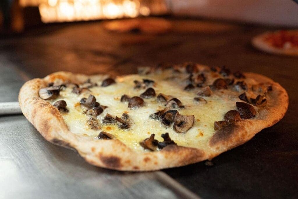 a pizza sitting on top of a wooden cutting board