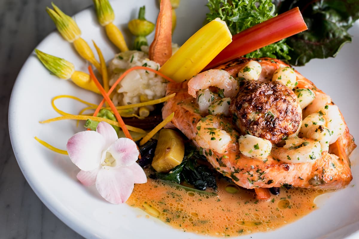 Scottish salmon fillet stuffed with shrimp, scallops, crab soufflé, and basil red pepper beurre blanc at Wild Garlic Grill