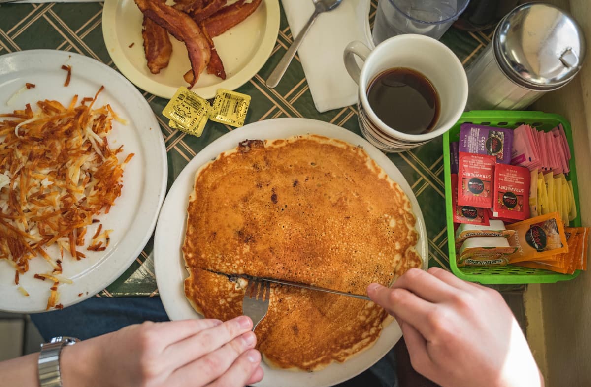 One pancake with a side of bacon and Hash Browns at Frank's