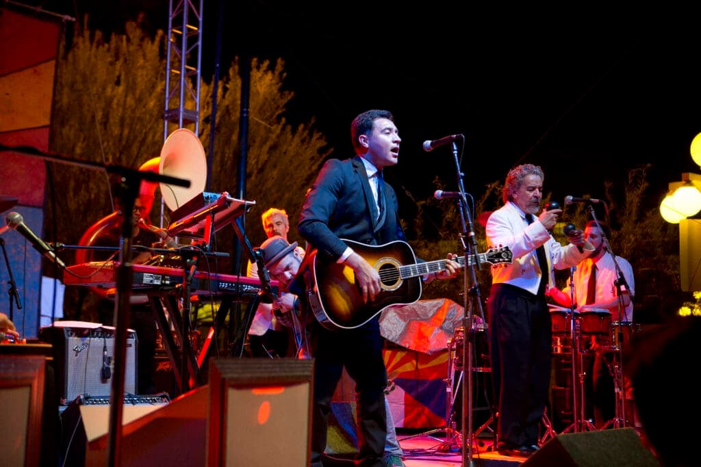 a group of people playing instruments and performing on a stage