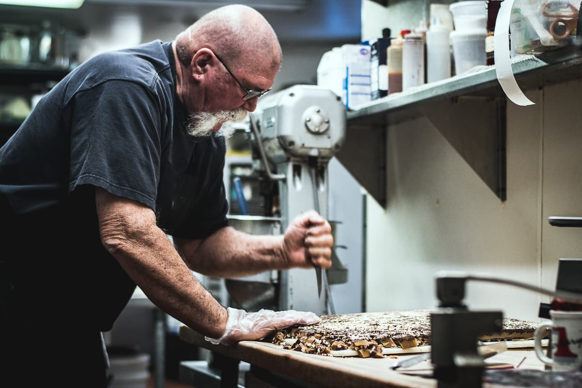 Chef Jonathan Landeen breaking Almond Roca into chunks at Jonathan's Cork (Credit: Jackie Tran)