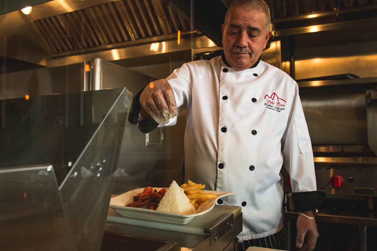 Walter Salazar garnishing Lomo Saltado at Villa Peru (Credit: Jackie Tran)