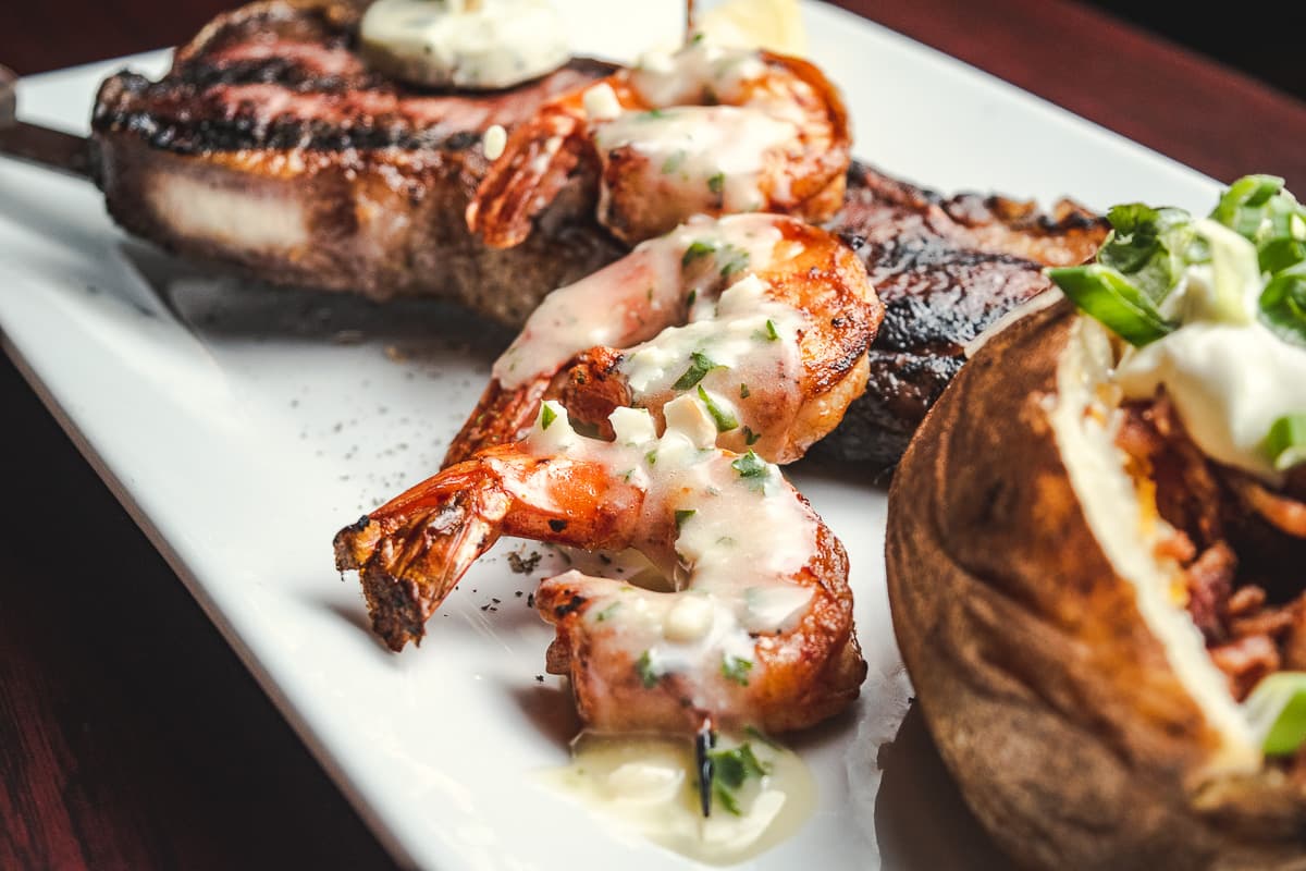 Dry-aged NY strip steak, shrimp skewer, and baked potato at the Horseshoe Grill (Credit: Jackie Tran)