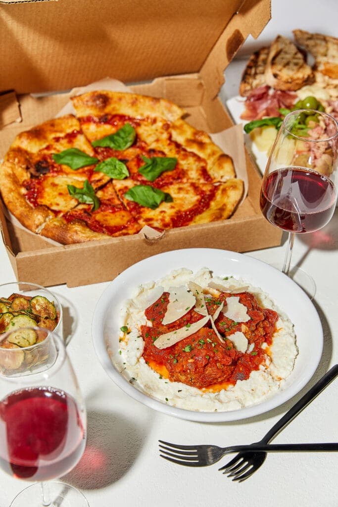 a box filled with different types of pizza sitting on top of a table