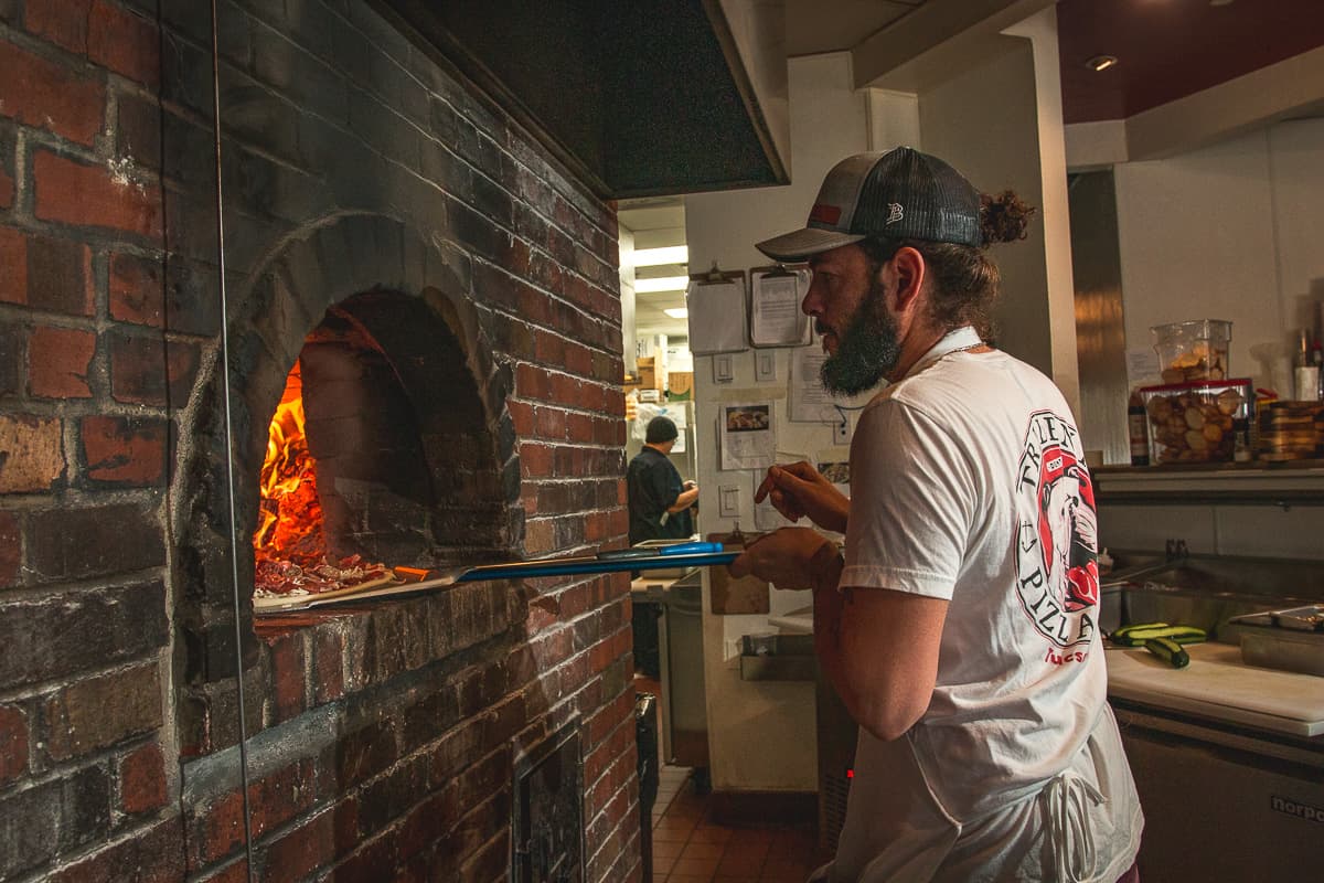 Eric Corbin loading pizza at Trident Pizza Pub (Credit: Jackie Tran)