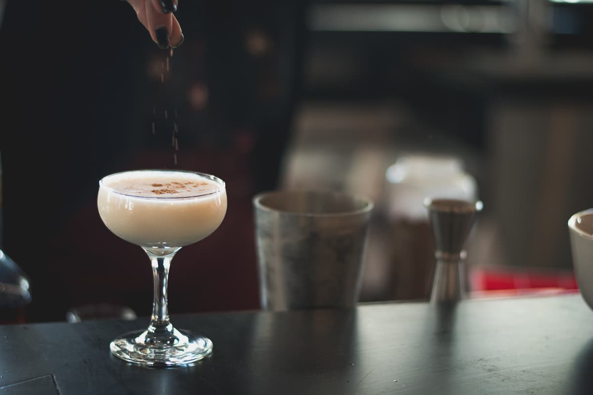 Bartender Tiffany Eldredge sprinkling nutmeg onto a brandy punch cocktail at Sazerac Creole Kitchen & Cocktails (Credit: Jackie Tran)