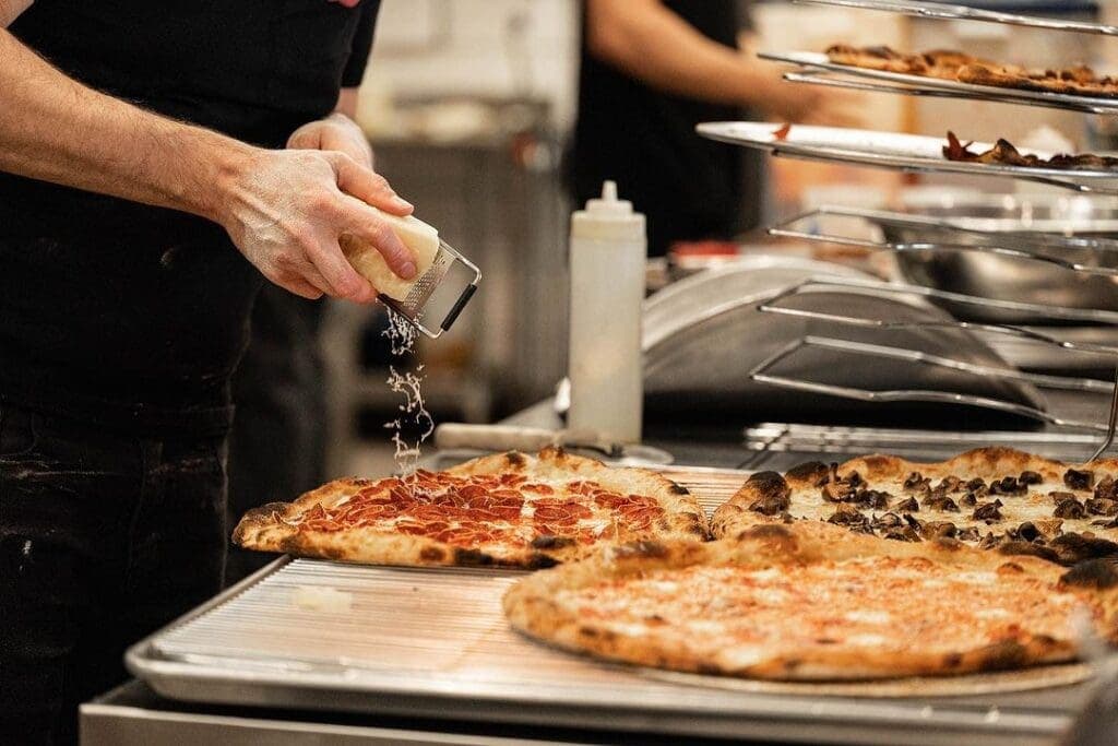a man is cutting into a pizza