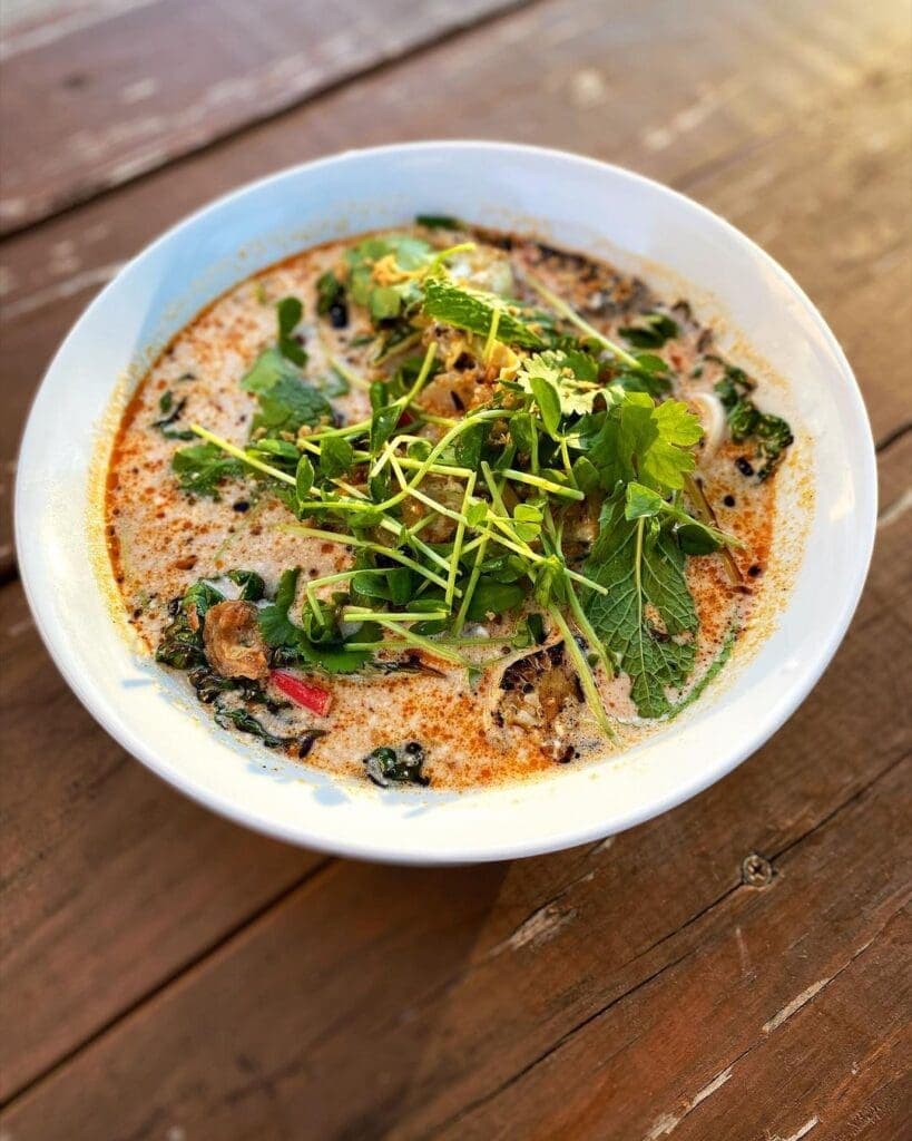 a bowl of food sitting on top of a wooden table