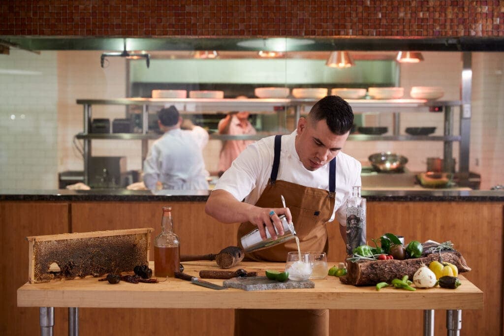 a person sitting on a kitchen counter preparing food