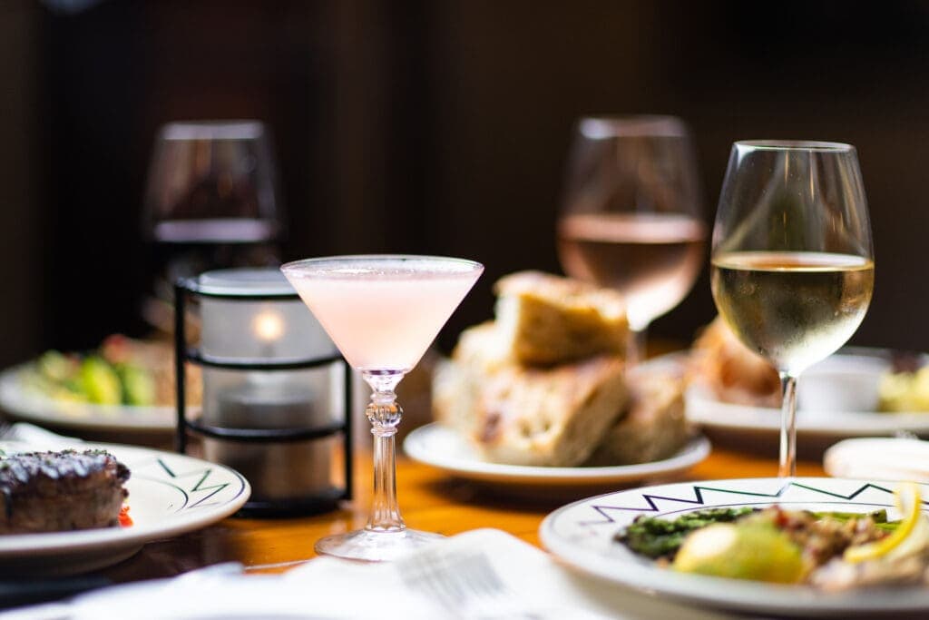 a plate of food and glasses of wine on a table