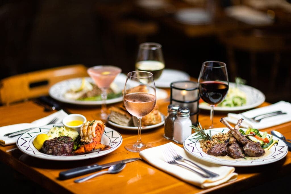 a plate of food and glasses of wine sitting on top of a table