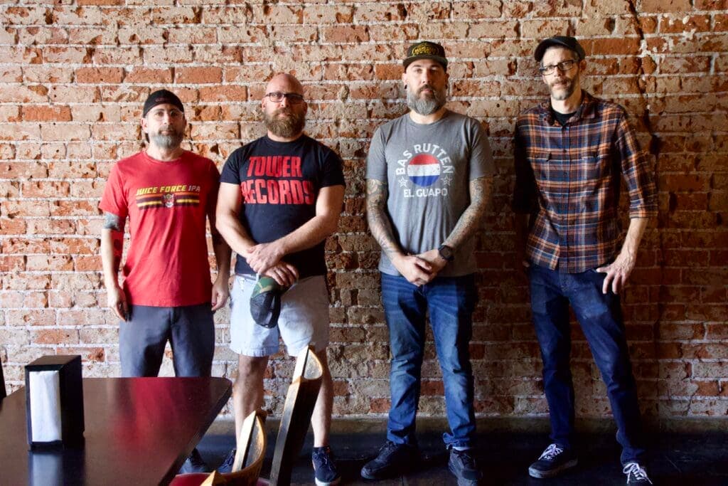 a group of people standing in front of a brick wall