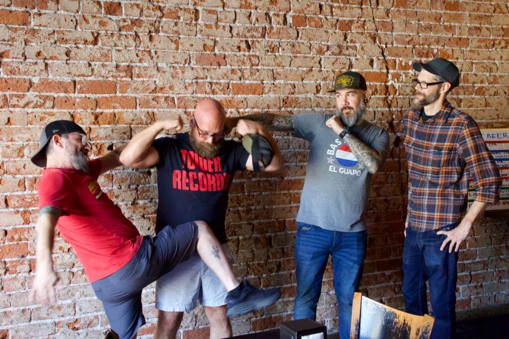 a group of people standing next to a brick wall