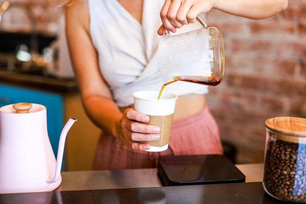 a person sitting at a table with a cup of coffee