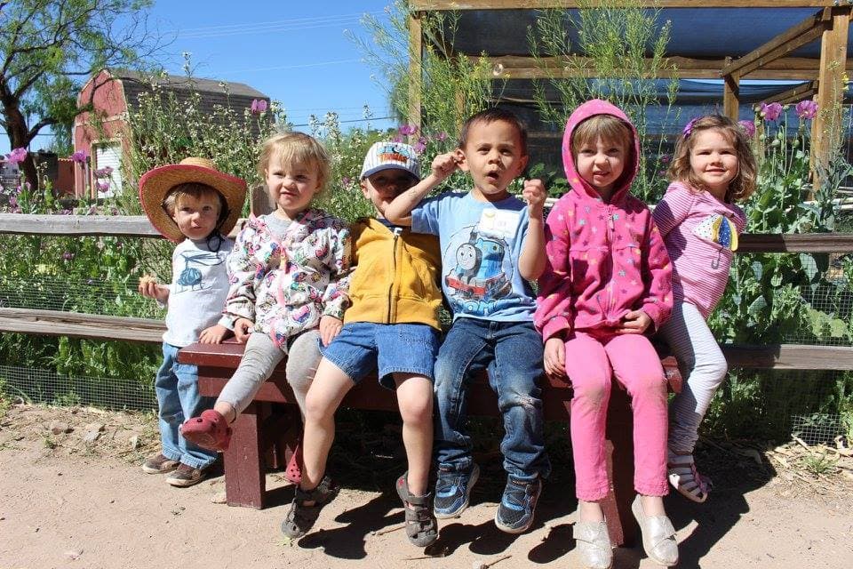 a group of people sitting on a bench posing for the camera