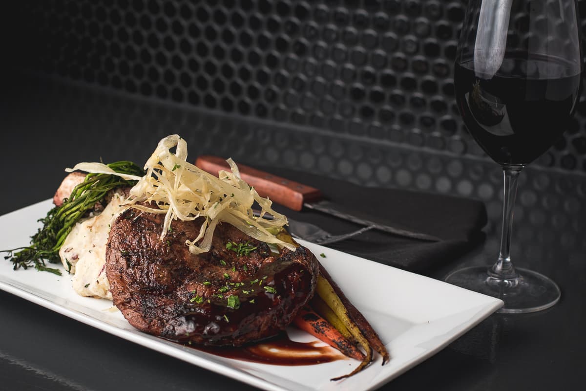 French-cut rib eye with rosemary-infused red mashed potatoes and grilled tri-colored carrots at The Horseshoe Grill (Credit: Jackie Tran)