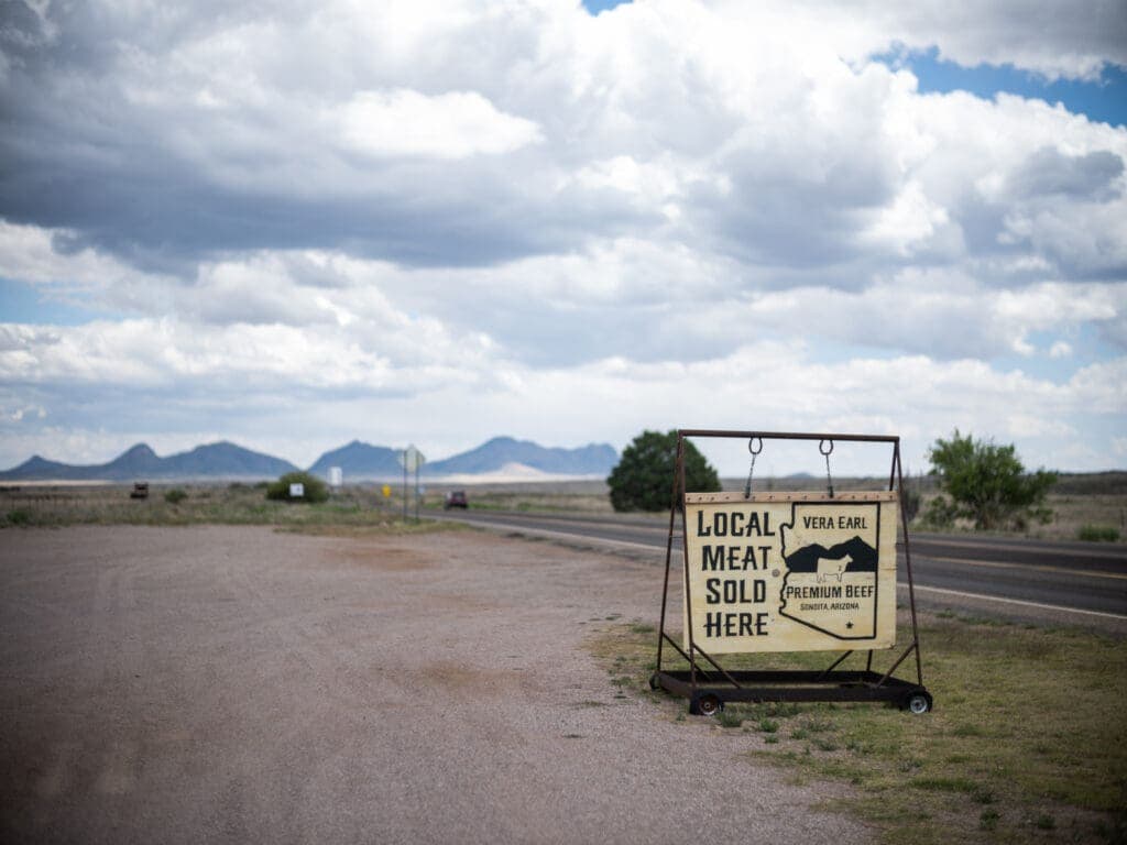 a sign on a dirt road
