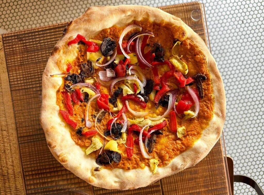 a pizza sitting on top of a wooden table