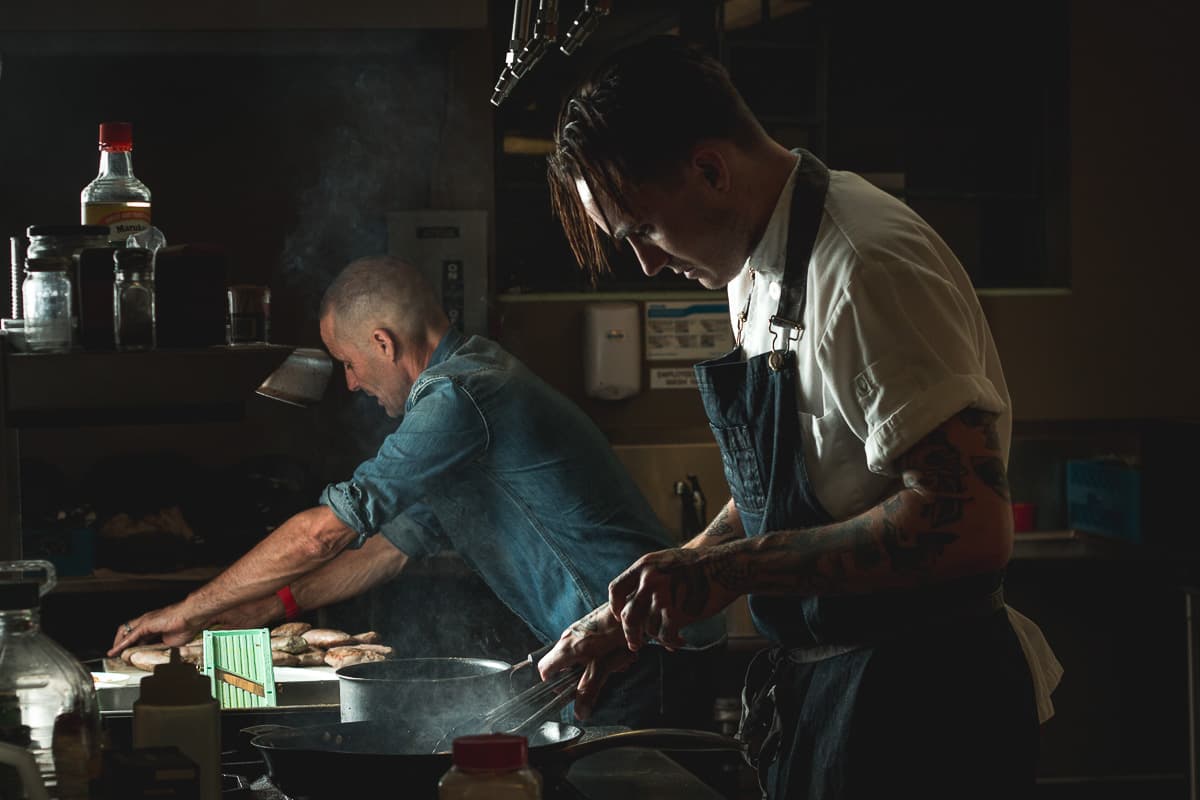 Chef Aidan Gould at his Blue Sky Cafe pop-up dinner at Sky Islands Public High School, preparing duck breast with his father (Credit: Jackie Tran)