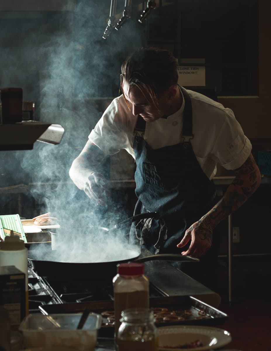 Chef Aidan Gould searing duck breast at Blue Sky Cafe at Sky Islands Public High School (Credit: Jackie Tran)