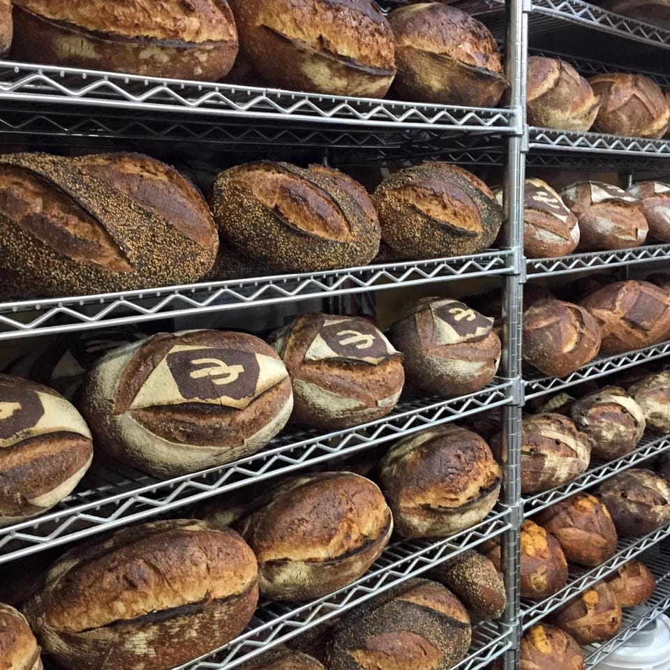 a picture of many loaves of bread on a wire shelf