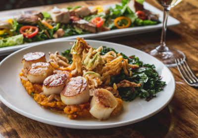 Seared Sea Scallops with kabocha puree, roasted cashews, shallots, Swiss chard, crispy summer and winter squashes, and dried apricot at Feast (Credit: Jackie Tran)