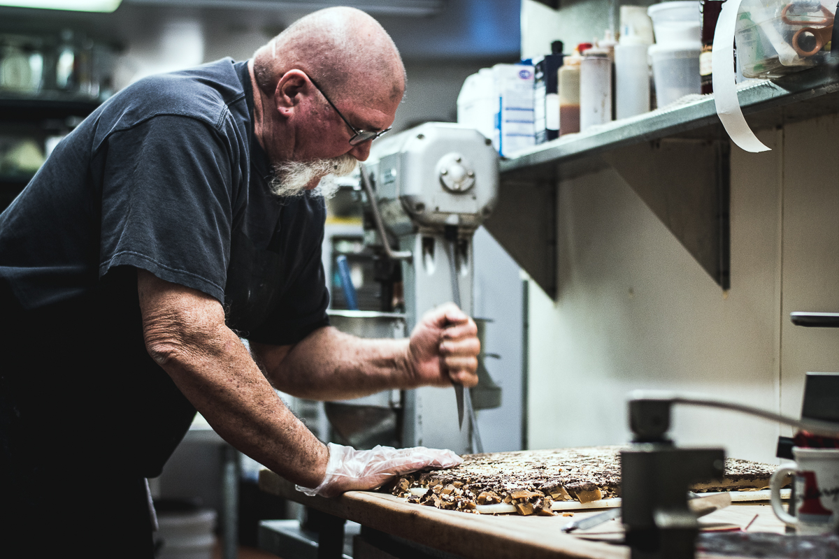 Chef Jonathan Landeen breaking Almond Roca into chunks at Jonathan's Cork (Credit: Jackie Tran)
