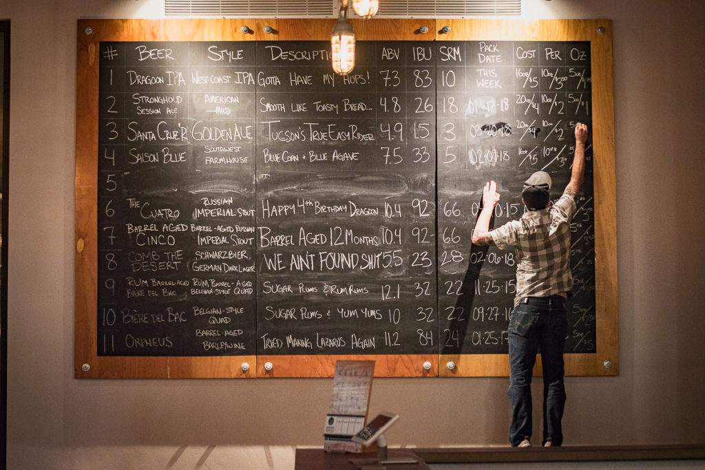 Dragoon Brewing Co. manager and co-founder Tristan White updating the beer list (Credit: Jackie Tran)