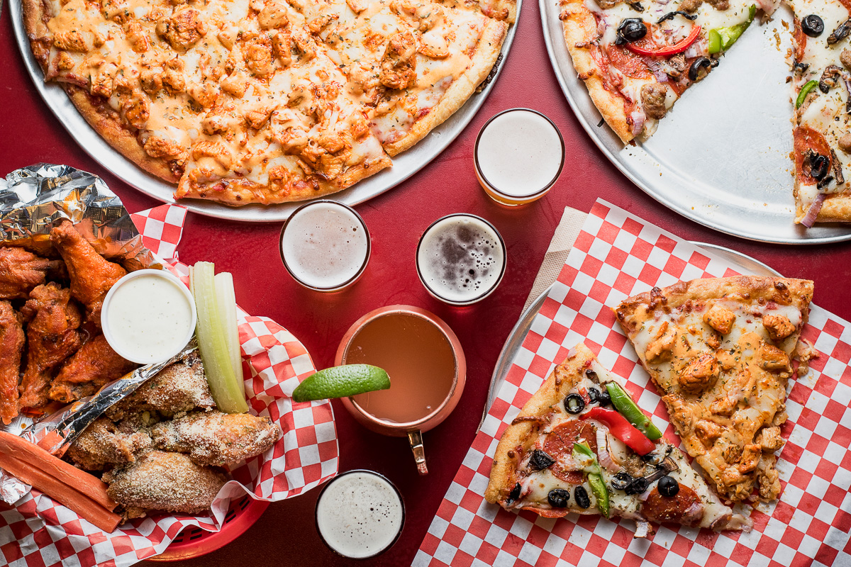 Pizza, wings, beer flight, and cocktail at Wings Over Broadway (Credit: Jackie Tran)