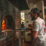 Eric Corbin loading pizza at Trident Pizza Pub (Credit: Jackie Tran)