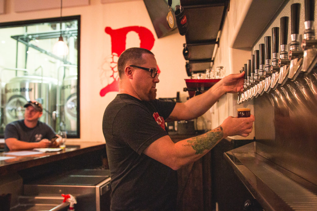 Todd Button pouring beer at Button Brew House