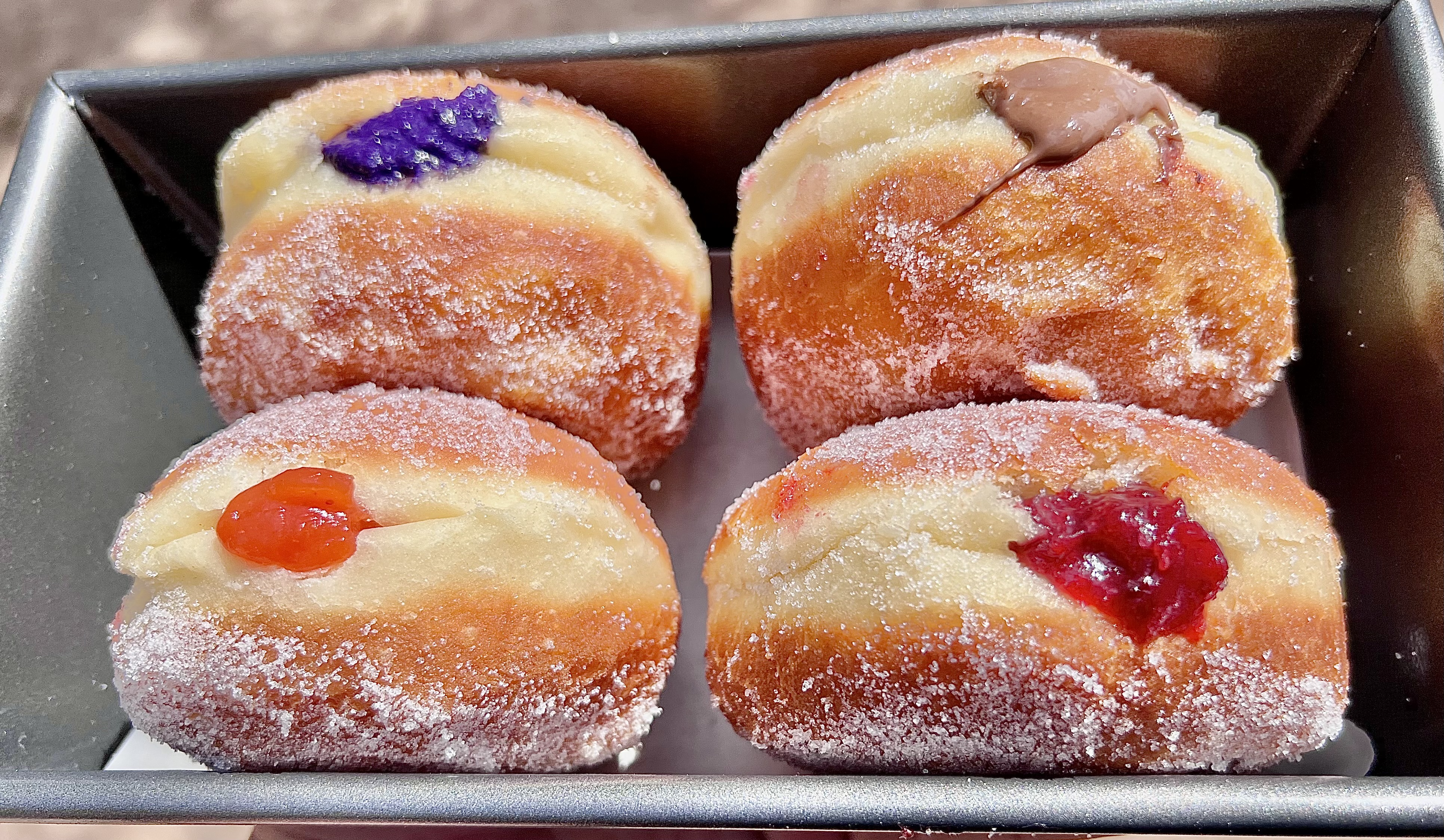 a picture of four cream and jelly filled donuts