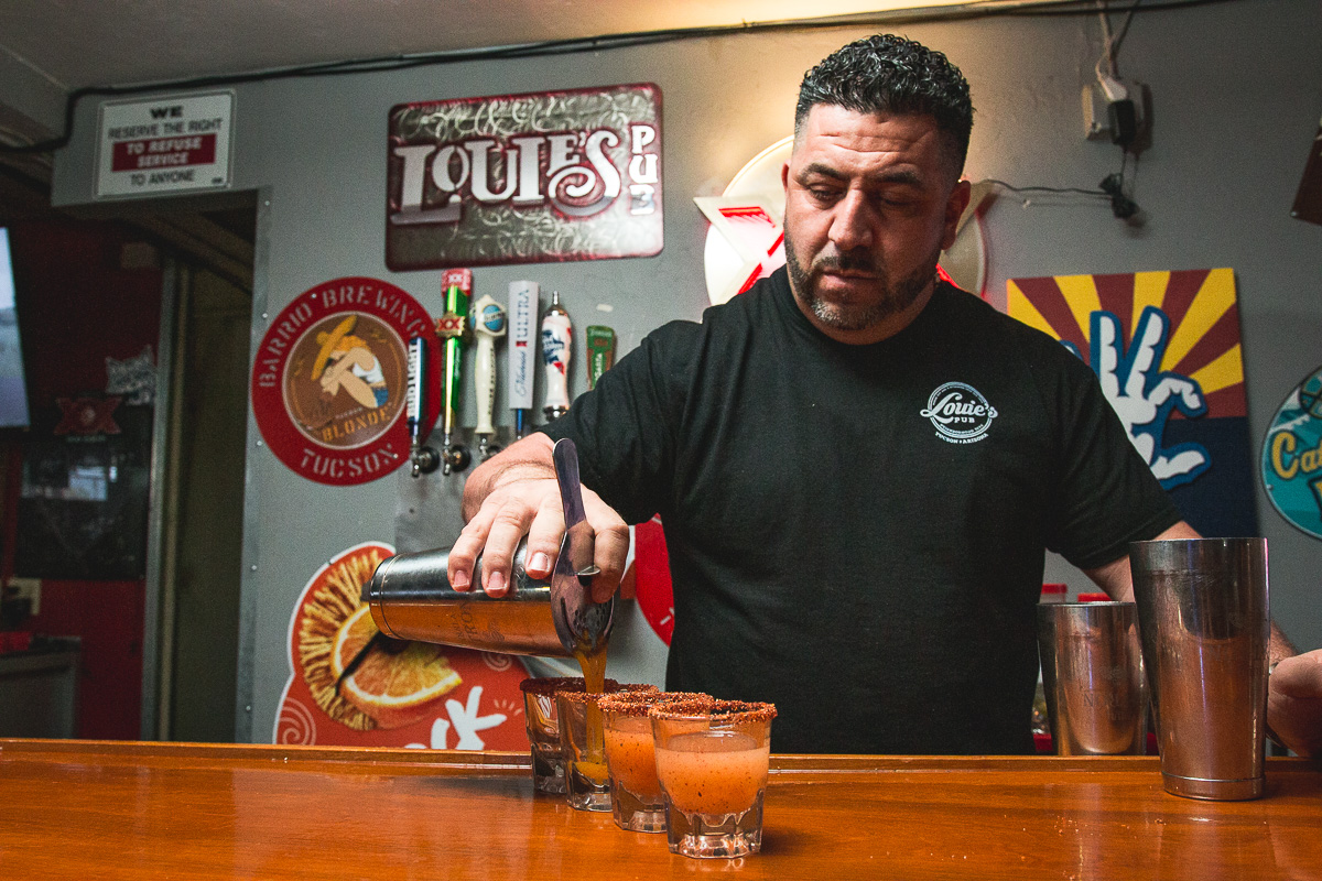 Co-owner Louie Lazos pouring shots of Kiss My Chile at Louie's Pub