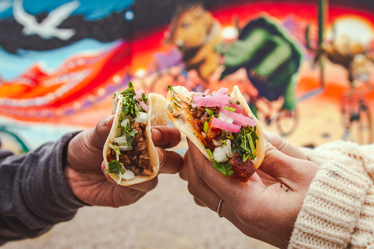 Street Taco and Beer Co. carne asada taco and al pastor taco in front of a Joe Pagac mural (Photo by Melissa Stihl)