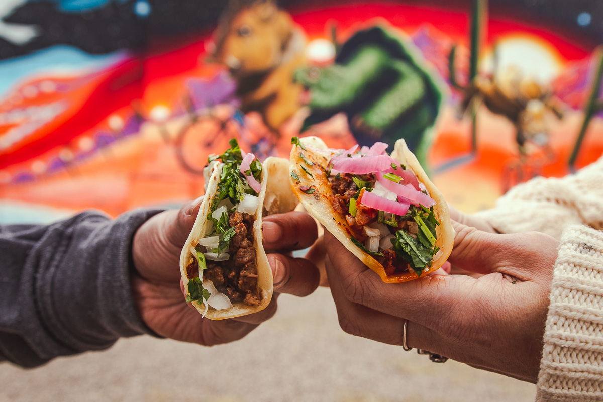 Street Taco and Beer Co. carne asada taco and al pastor taco in front of a Joe Pagac mural (Photo by Melissa Stihl)