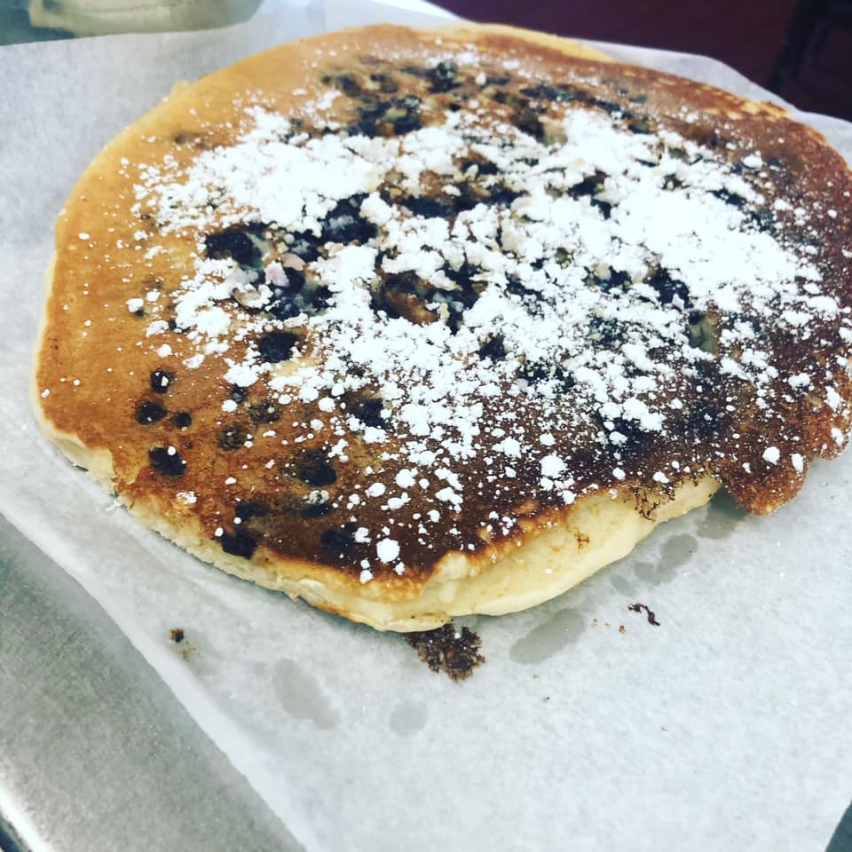 a chocolate chip pancake sprinkled with powdered sugar