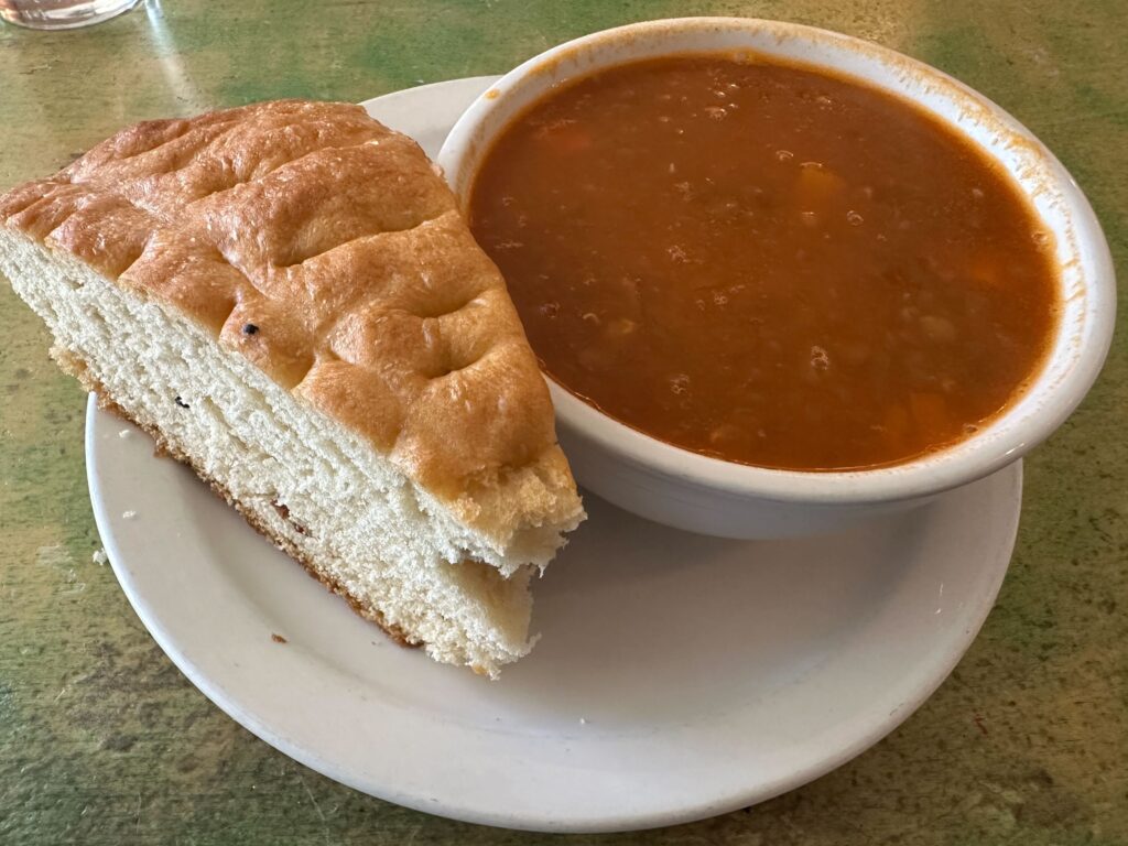 a bowl of soup and a sandwich on a plate