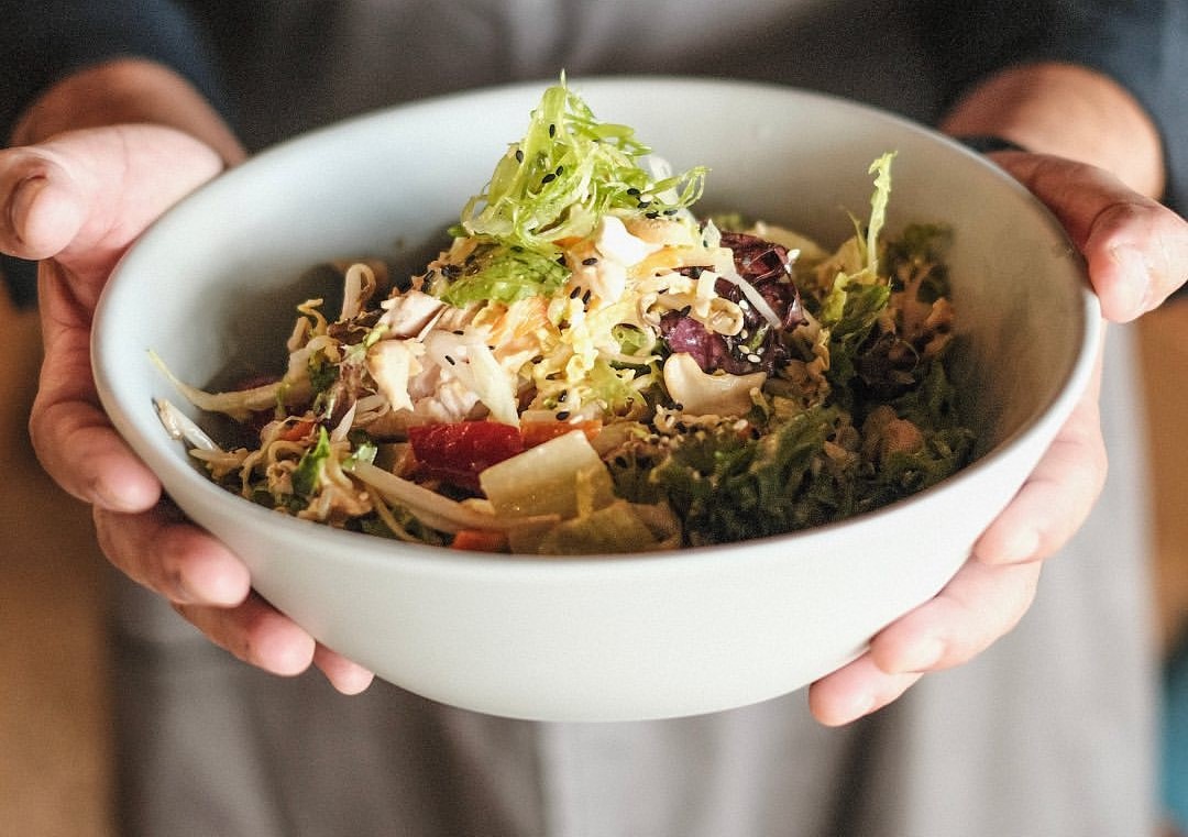 a hand holding a bowl of food