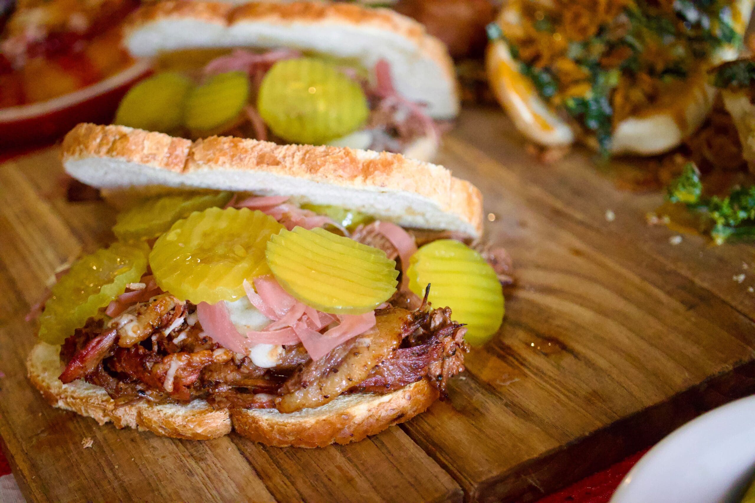 a cut in half sandwich sitting on top of a wooden cutting board